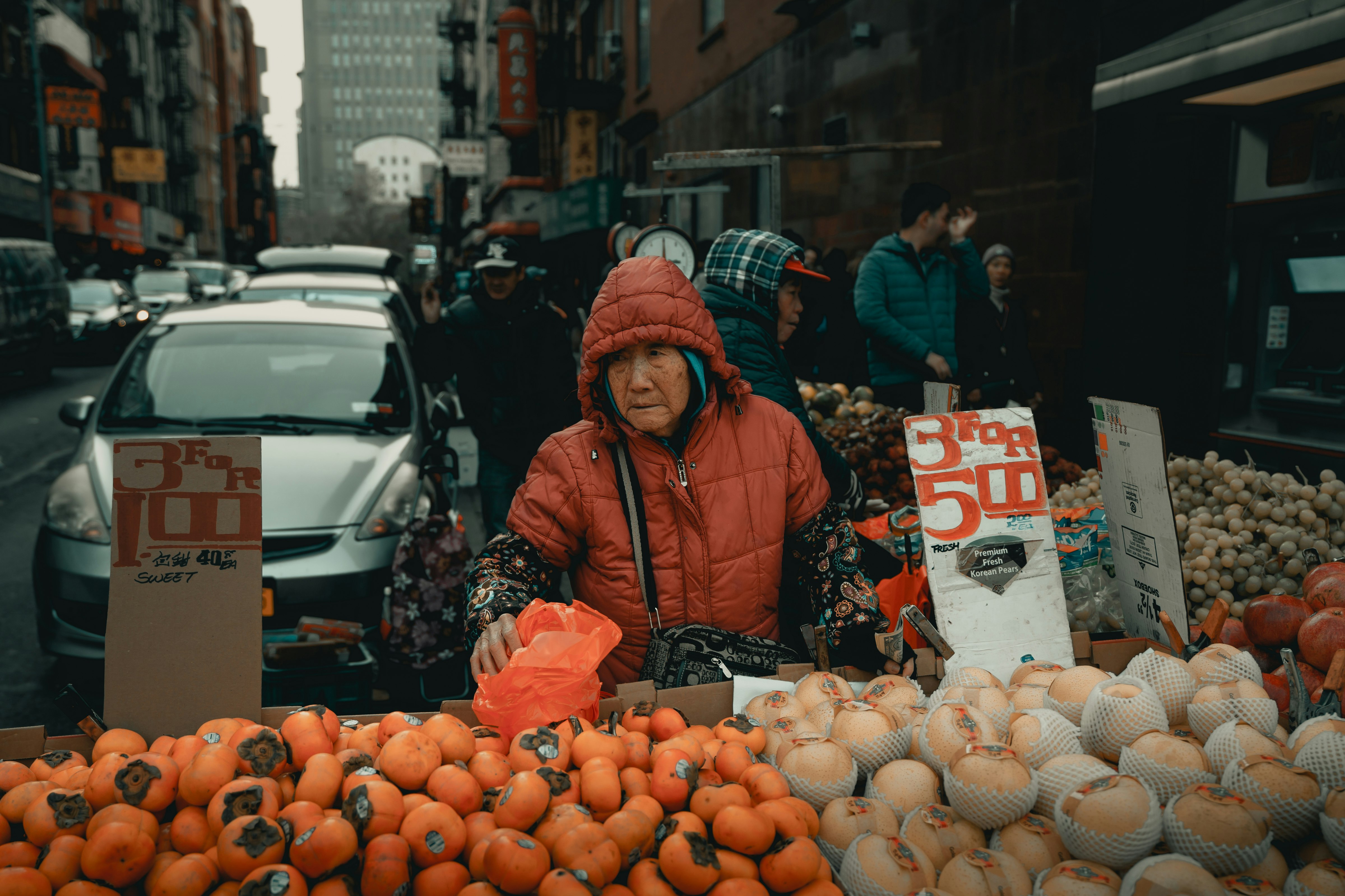 Woman selling fruits near park vehicle on street during day time